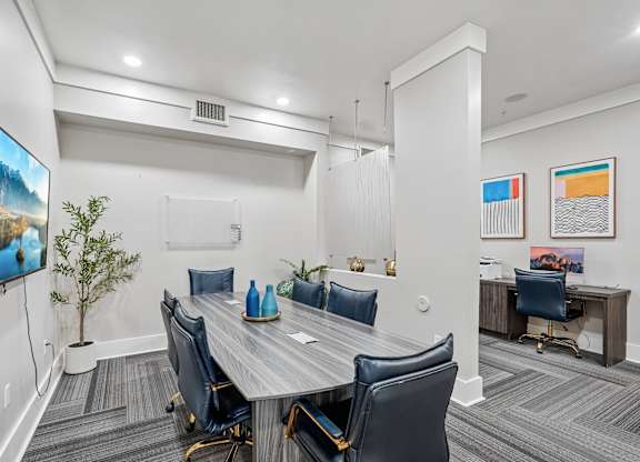 A conference room with a large table and chairs.