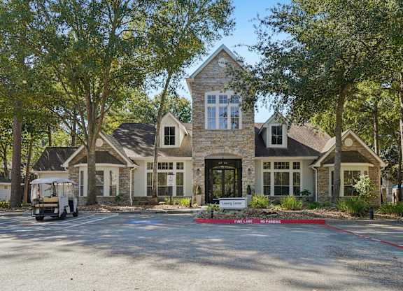 A large house with a stone facade and a sign that says "Fairlane.".