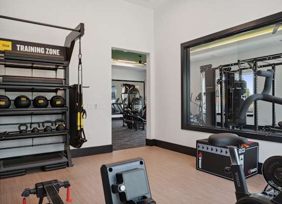 A gym with a TRX training zone sign.