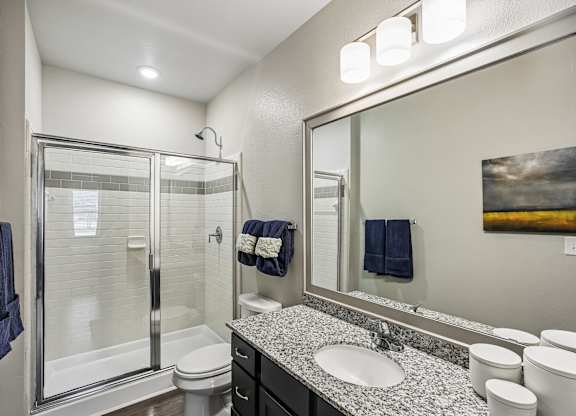 A bathroom with a white toilet, sink, and mirror.