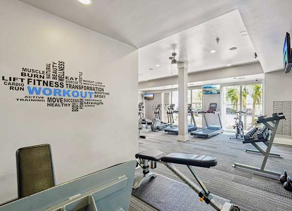 A gym with a wall of words related to fitness and exercise equipment.
