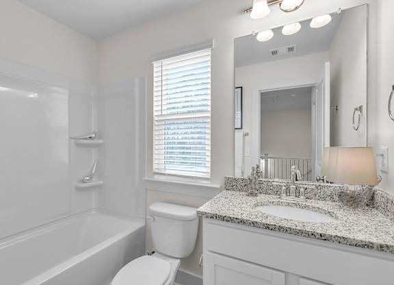 A white bathroom with a sink, toilet, and bathtub.