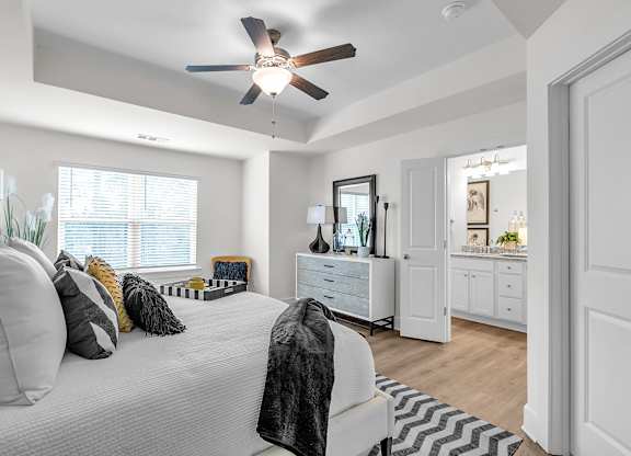 A bedroom with a bed, dresser, and mirror.
