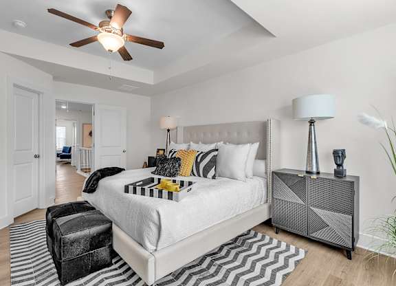 A bedroom with a large bed and a ceiling fan.