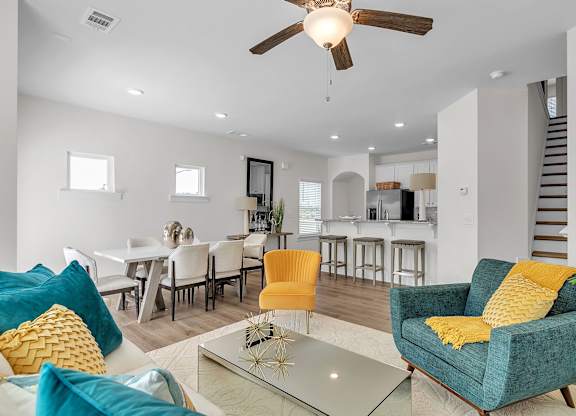 A living room with a blue chair and yellow pillow.