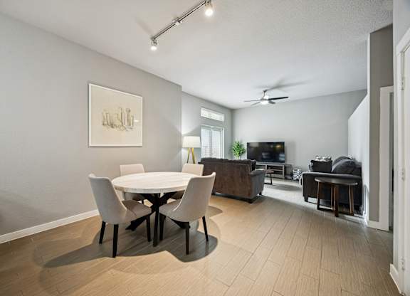 A modern dining room with a white table and chairs.