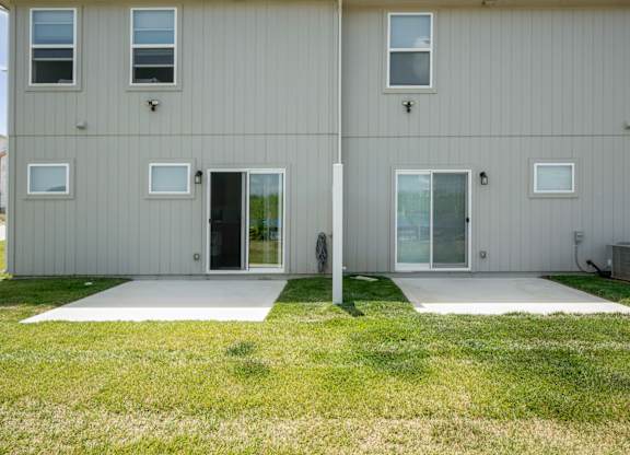 A two-story house with a grey exterior and white trim.