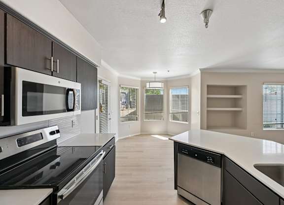 A modern kitchen with a black stove top oven and a microwave above it.