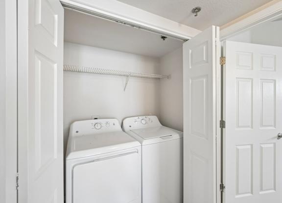 A white washing machine and dryer in a small laundry room.