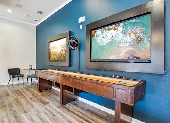 A room with a blue wall and a wooden desk with a chair.