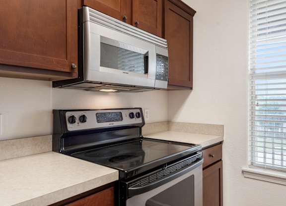 A black stove top oven sits under a microwave in a kitchen.