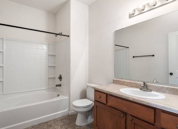 A white bathroom with a tub, toilet, and sink.