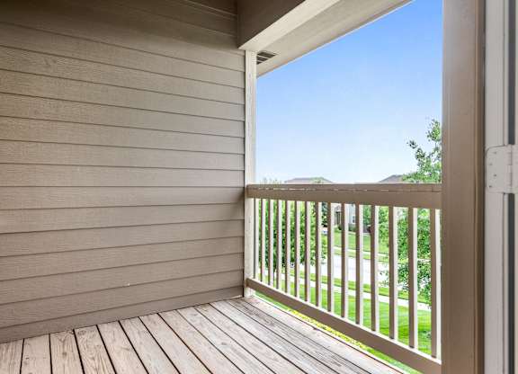 A balcony with a view of a street and houses.