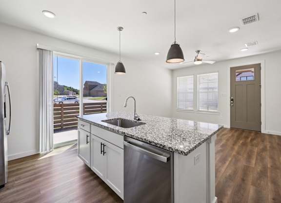 A kitchen with a granite countertop and stainless steel appliances.