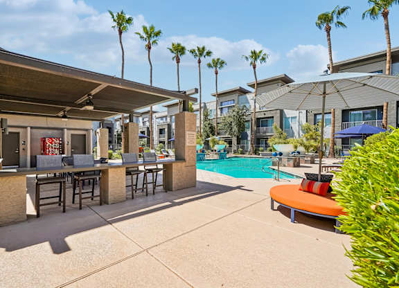 A poolside area with a bar and lounge chairs.