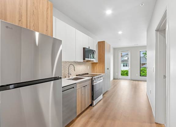 A modern kitchen with wooden cabinets and stainless steel appliances.