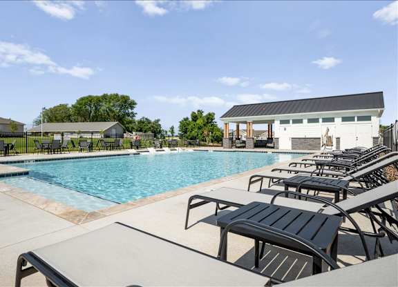 A pool with a black fence and a white building in the background.