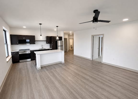 A spacious kitchen with a white island and wooden flooring.