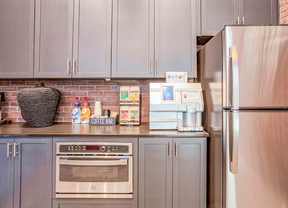 A kitchen with a refrigerator, oven, and cabinets.