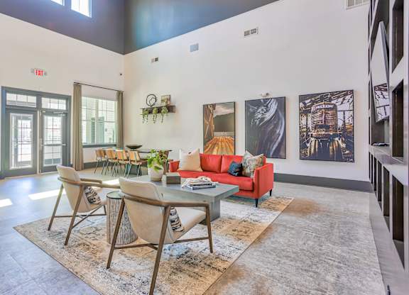 A living room with a red couch and a glass table.