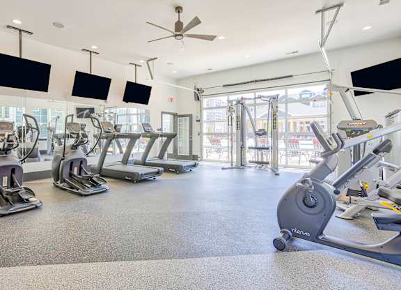 A gym with treadmills and elliptical machines.