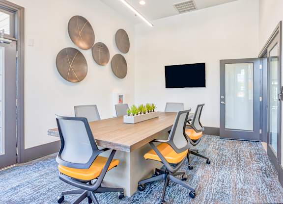A conference room with a long table and chairs.
