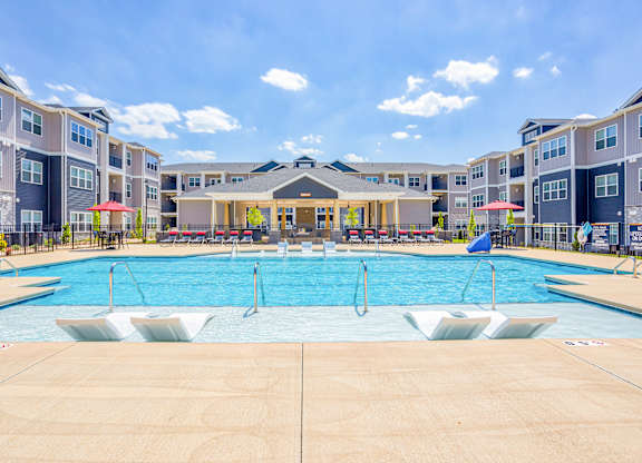 A large swimming pool in front of apartment buildings.