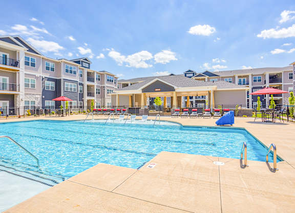 A large swimming pool in front of apartment buildings.
