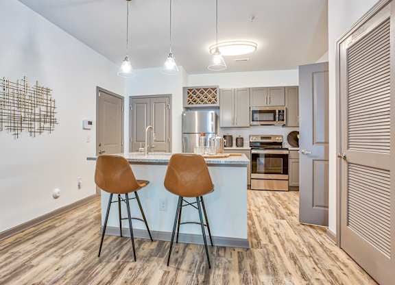 A kitchen with a bar area and two chairs.