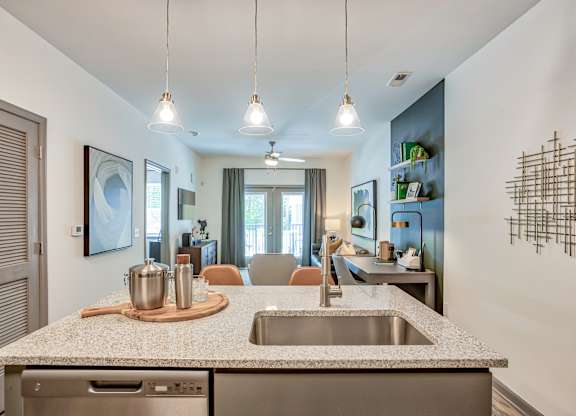 A kitchen with a granite countertop and stainless steel appliances.