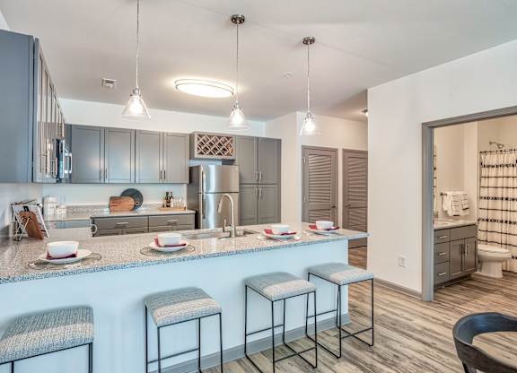 A kitchen with a bar area and a dining table.