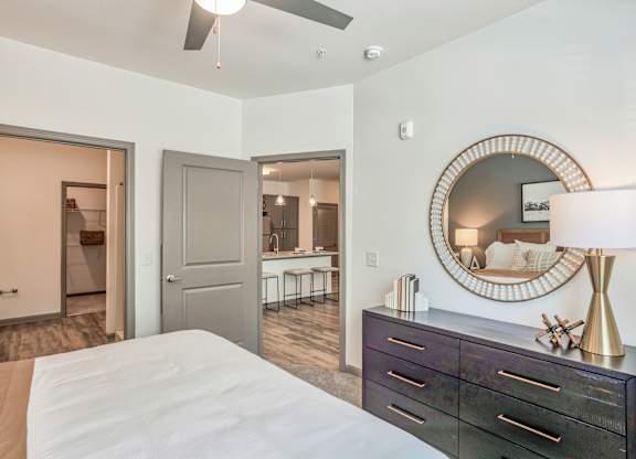 A bedroom with a bed, dresser, and mirror.
