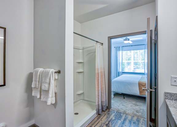 A white bathroom with a towel hanging on the wall.