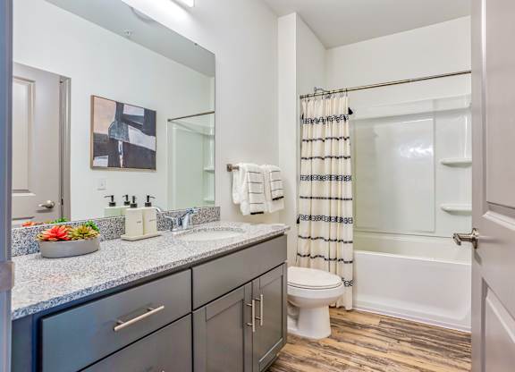 A bathroom with a toilet, sink, and shower.
