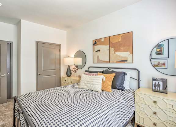 A bedroom with a bed, dresser, and mirror.