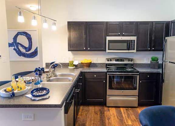 A kitchen with dark brown cabinets and stainless steel appliances.
