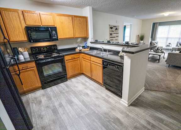 A kitchen with wooden cabinets and black appliances.