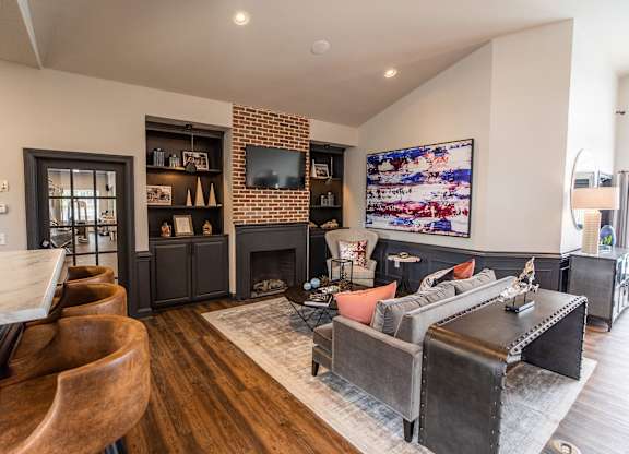 A living room with a fireplace and a TV on the wall.