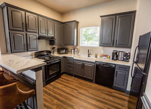 A kitchen with black cabinets and a white counter top.