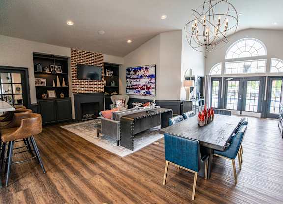 A modern living room with a dark wood floor and a large chandelier.