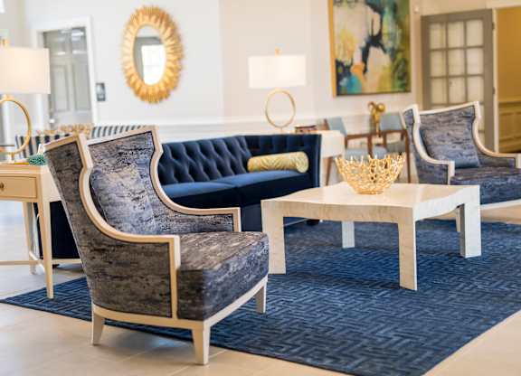 A living room with a blue couch and a grey chair.