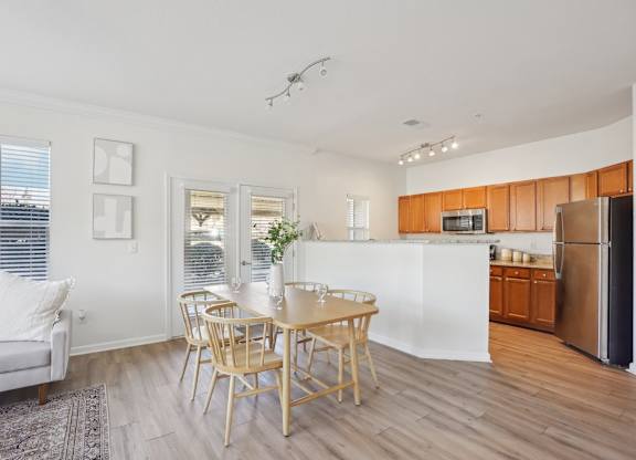 A modern kitchen with a dining table and chairs.