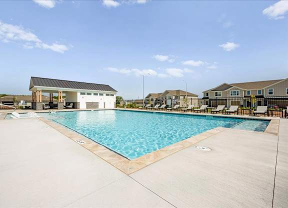 A large swimming pool with a building in the background.