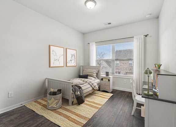 A bedroom with a bed, nightstand, and chair.