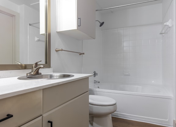 A white bathroom with a toilet, sink, and bathtub.