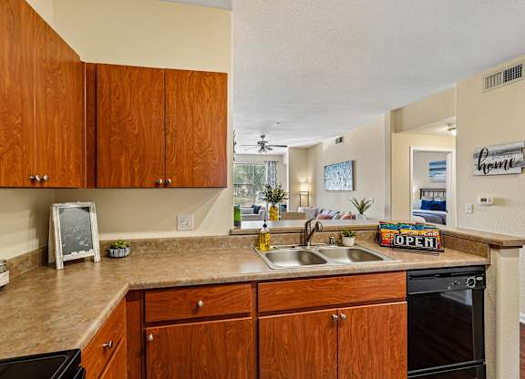 A kitchen with wooden cabinets and a countertop with a sign that says
