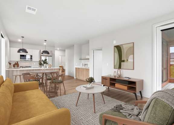 A living room with a yellow sofa and a grey rug.