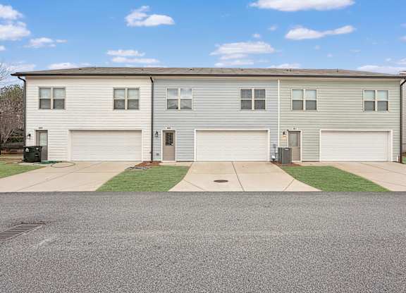 A row of houses with garages and driveways.