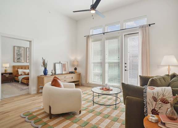 A living room with a brown couch, a white chair, and a coffee table.