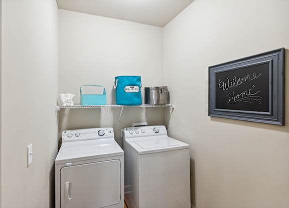 a washer and dryer in the laundry room at the enclave at woodbridge apartments in